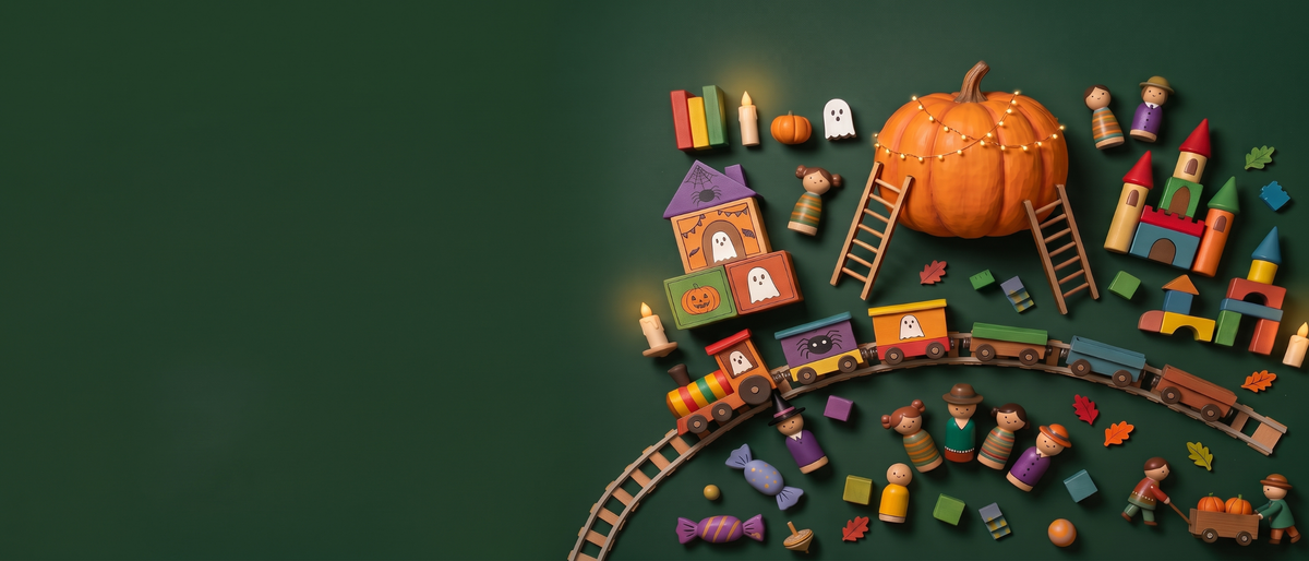 Holzspielzeug für Halloween von oben auf dunkelgrünem Grund: großer Kürbis mit Lichterkette, Holzeisenbahn, Burg aus Bauklötzen, Spielfiguren und Herbstblätter
