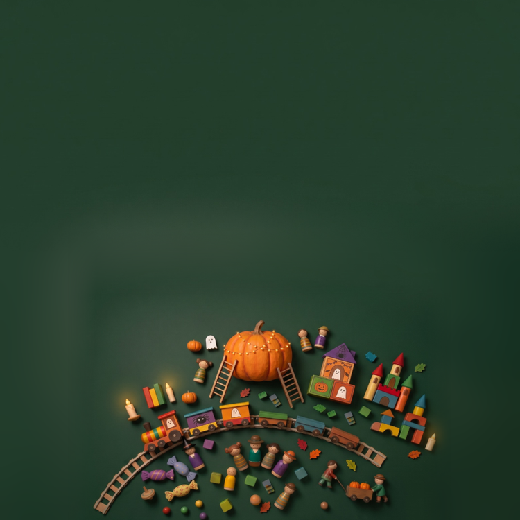 Holzspielzeug für Halloween von oben auf dunkelgrünem Grund: großer Kürbis mit Lichterkette, Holzeisenbahn, Burg aus Bauklötzen, Spielfiguren und Herbstblätter